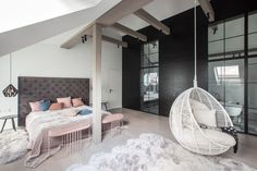 a bedroom with a hanging chair and bed