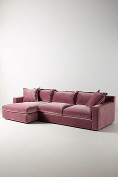 a pink couch sitting on top of a white floor