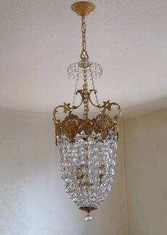 a chandelier hanging from the ceiling in a room with white walls and flooring