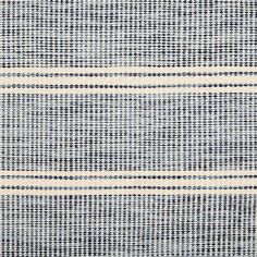 a blue and white striped rug with black dots on the bottom, in an area that is