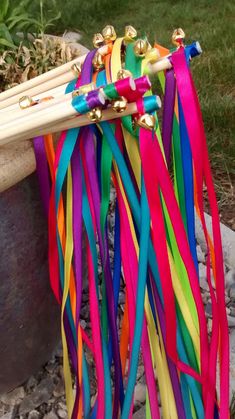 a bunch of colorful streamers are hanging from a planter in front of some rocks