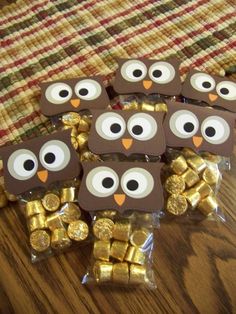 chocolate owls are sitting on the table with gold coins in front of them and one has eyes that look like an owl