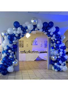 a blue and white balloon arch in the middle of a room