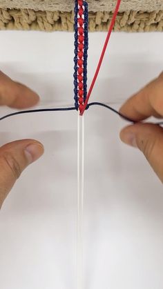 two hands are working on a piece of string