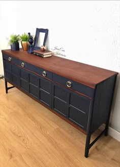 a black and brown dresser sitting on top of a hard wood floor