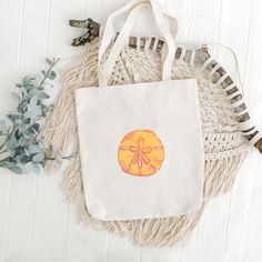 This Sand Dollar Cotton Canvas Tote Bag is the perfect blend of coastal charm and bright sunshine colors. Whether you're heading to the beach, strolling through a farmer's market, or simply running errands around town, this tote bag is your ideal companion. 🐚 Design: The Sand Dollar Tote Bag features a bright print of a watercolor painting that evokes the shine of a sunny day at the beach. The sand dollar will remind you of peaceful days with your toes in the sand. The print is on one side of the tote. The other side is blank. 🌞 Quality: Crafted from high-quality, durable cotton canvas, this tote bag is built to withstand the test of time. Rest assured that you can carry your essentials, from groceries and books to beach towels and sunscreen, all without compromising on strength or style Cotton Tote Beach Bag For Beach Season, Cotton Beach Tote Bag For Beach Season, Natural Cotton Canvas Beach Bag, Casual Canvas Beach Bag Perfect For Gift, Casual Canvas Beach Bag, Beige Cotton Beach Bag For Beach Season, Natural Canvas Bag For Summer Gift, Natural Cotton Beach Bag For Vacation, Natural Cotton Beach Bag For Beach Season