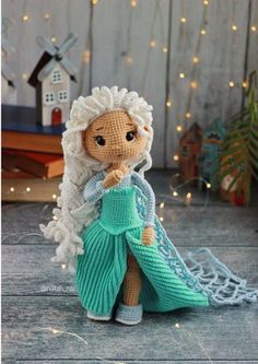 a knitted doll with white hair wearing a green dress