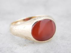 This beautiful antique mounting is crafted of rose gold, a warm color created by alloying with copper. This beautiful styled ring could be for a man or a woman, and has simple engraving on the sides and a warm rich Carnelian center. Carnelian is the reddish-orange version of Chalcedony, and can either be uniformly colored or have visible bands through the stone. Metal: 14K Yellow Gold Gem: Carnelian Gem Measurements: 9.2 x 12 mm, Curved Cut Oval Ring Size: 7.25 Marks: "14" Stamped on the inside Oval Ring, Oval Rings, Yellow Gold Ring, Ring Size 7, Eternity Bands, Yellow Gold Rings, Rings Statement, Warm Colors, Etching