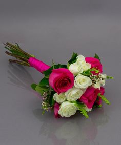 a bridal bouquet with pink and white flowers on a gray surface, ready to be used as a bride's bouquet