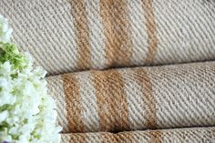 a bouquet of white flowers sitting on top of a brown and tan couch next to a wall