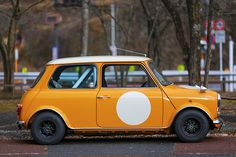 an orange and white car is parked on the street