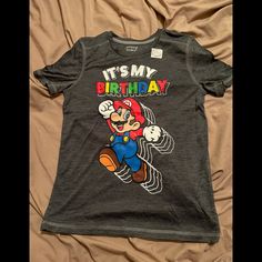 a gray shirt with an image of mario on it's chest and the words, it's my birthday