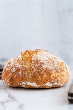 a loaf of bread sitting on top of a counter next to a cell phone and remote control