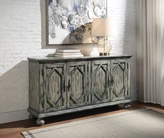 the sideboard is painted blue and has an ornate design on it, along with a lamp