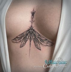 the back of a woman's shoulder with a dragonfly tattoo on it