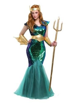 a woman in a green and blue mermaid costume with gold gloves on her head, standing