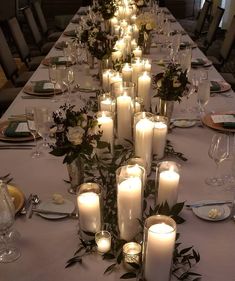 a long table is set with candles and place settings