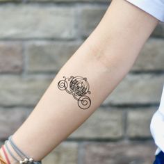 a woman's arm with a tattoo on it and a brick wall behind her