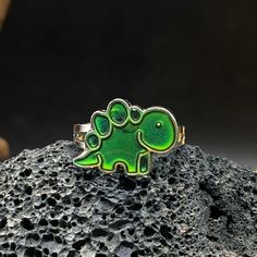 🐬Product Name:Color Changing Dinosaur Ring 🐬Material：Sliver 🐬Band color：Multicolor 🐬Style：art decor,Christmas gift,new year,Anniversary 🐬Personalized：Yes 🐬Recycled：Yes 🐬Occasion : Anniversary / Daily / Wedding / Gift / Party/birthday/Valentine's Day/Engagement/Mother's Day/Father's Day 🐬Metal:Sliver 🐬Metal Color:Multicolor 🐬Style:Art Decor,Hiphop,party,dance,Gift, 🐬About Size:Height: about 1.28cm Thickness: about 0.08cm Width: about 0.34cm We can provide personalize ring sizes of 7-12 Green Novelty Jewelry For Birthday, Novelty Dinosaur Print Jewelry Gift, Casual Green Jewelry For Party, Casual Metal Rings For Gifts, Casual Green Nickel-free Jewelry, Casual Adjustable Rings For Gifts, Casual Adjustable Rings As Gifts, Novelty Silver Jewelry For Birthday, Dinosaur Ring