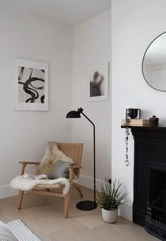 a living room with a chair, mirror and fireplace