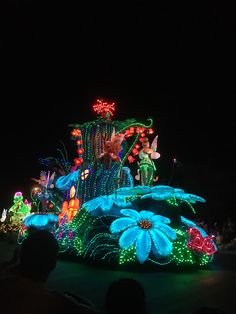 a float decorated with flowers and lights at night