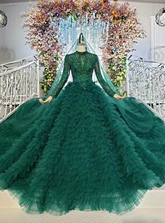 This amazing and elegant ball gown crafted with lots of design is just for you. It has some unique features. Starting from the top to bottom, a nice greenish long veil is added to this gown with a neckline of the high neck. A basket design with some green materials and shiny beads is also added showing the beauty of this gown. It has a built-in bra, so you don't need another one. Covering your hands is not a problem because this magnificent gown has a long Sleeve perfectly fitted. This wedding dress made from tulle fabrics has a lace-up back style. From the waist downwards, there are some fine fold up around it, and some small coated designs. Dark Green Ball Gown, Dubai Wedding Dress, Green Couture, Dress With Veil, Blue Princess Dress, Debut Gowns, Green Ball Gown, Debut Dresses, Vintage Wedding Gown