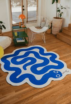 a blue and white area rug on the floor in a living room with wooden floors