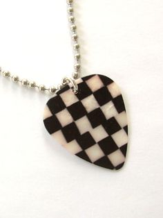 a black and white checkered guitar pick on a ball chain