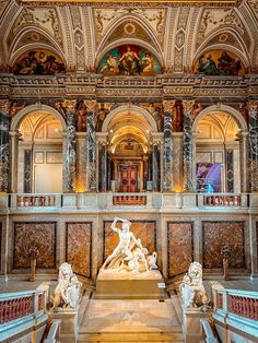 the interior of a building with statues and paintings on the walls, along with marble steps