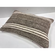 a brown and white striped pillow sitting on top of a table