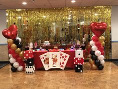 a table set up for a casino themed birthday party with balloons and streamers on the wall