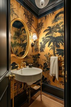 the bathroom is decorated in gold and black with palm trees on the wall behind the sink