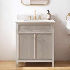 a bathroom with a sink, mirror and towel rack