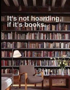 a chair and table in front of a book shelf with many books on the shelves