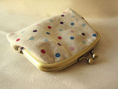 a polka dot purse sitting on top of a white sheet