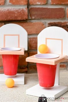 two plastic cups with oranges in them sitting next to each other on top of a table