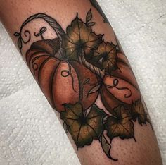 a close up of a person's leg with a pumpkin tattoo design on it