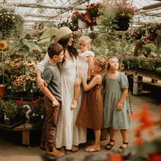 a group of people standing around each other in a greenhouse