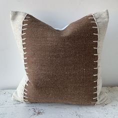 a brown and white pillow sitting on top of a wooden table