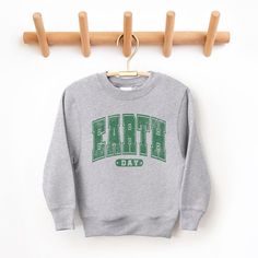 Looking for a cute sweatshirt for your kids? We have the perfect Earth Day Varsity graphic sweatshirt addition to their closet! Also available in toddler sweatshirts. Green Varsity Crew Sweatshirt, Green Graphic Print Crew Sweatshirt, Sporty Heather Grey Graphic Sweatshirt, Earth Day Graphic Tee With Crew Neck, Trending Graphic Tees, St. Patrick's Day Graphic Print Crew Neck Top, Cute Sweatshirts, Kids Outfits Girls, Top Graphic Tees