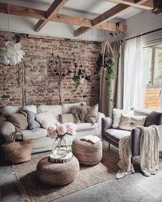 a living room filled with lots of furniture next to a brick wall covered in potted plants