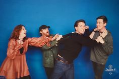 four people standing in front of a blue background