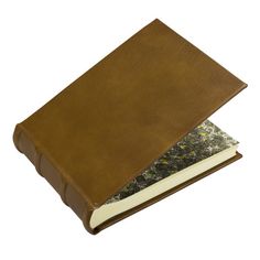 a brown leather book sitting on top of a white surface