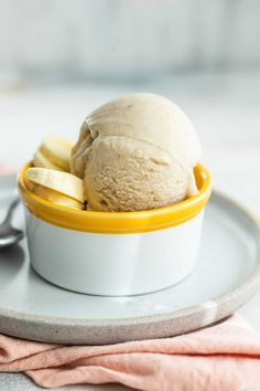 a scoop of ice cream sits in a bowl on a plate