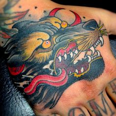 a hand with a tattoo on it and an animal's head in the middle