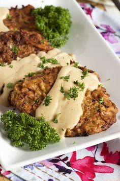 two meat patties covered in gravy and garnished with parsley