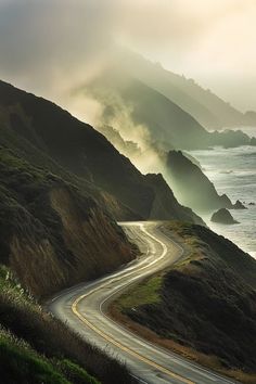 a winding road on the side of a mountain near the ocean