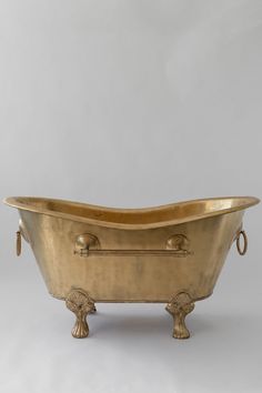 an antique brass bathtub with handles and feet