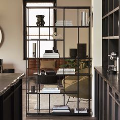 a living room filled with furniture next to a tall book shelf on top of a hard wood floor