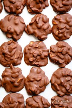 chocolate cookies are arranged in rows on a white surface, ready to be baked or eaten